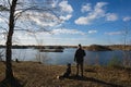 The owner walks with a husky dog Ã¢â¬â¹Ã¢â¬â¹in nature near a lake on an autumn day